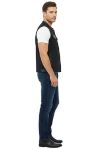 Man wearing a black vest over a white shirt with blue jeans on a white background