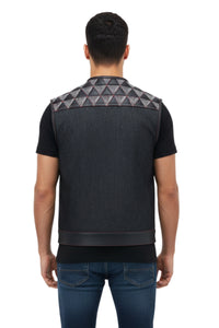 Man wearing a black vest with geometric pattern on the back, standing against a white background