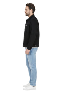 Man wearing a black jacket and light blue jeans on a white background