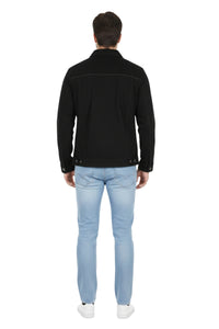 Person wearing a black jacket and light blue jeans on a white background
