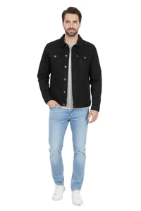 Man wearing a black denim jacket, light blue jeans, and white sneakers on a white background