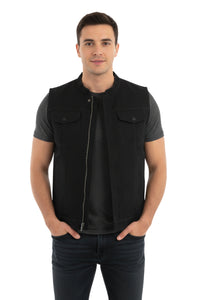 Man wearing a black vest over a dark shirt on a white background