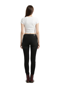 Person wearing black jeans and a white crop top on a white background