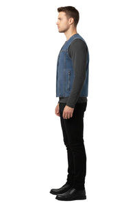 Man wearing a blue denim vest over a dark long-sleeve shirt and black pants on a white background