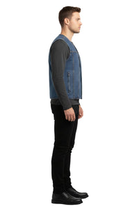 Man wearing a denim vest over a black shirt and pants on a white background