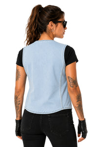 A woman shown from the back wearing a light blue denim sleeveless vest over a black t-shirt, paired with black jeans and black fingerless gloves, against a plain white background.