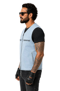 A man in profile wearing a light blue denim motorcycle vest over a black t-shirt, black jeans, black fingerless gloves, and sunglasses, photographed against a solid white background.