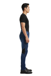Person wearing blue jeans with black accents on a white background