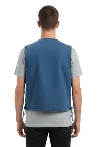 Person wearing a blue vest over a gray shirt on a white background