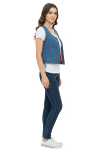 Woman wearing a blue denim vest over a white shirt on a white background