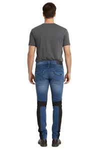 Man wearing blue jeans with black patches on a white background