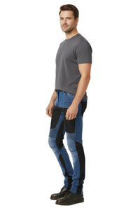 Man wearing a gray t-shirt and blue and black biker jeans on a white background