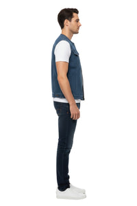 Man wearing a blue denim vest over a white shirt on a white background
