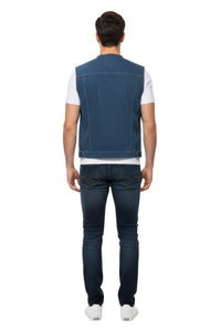 Person wearing a blue vest over a white shirt with dark jeans on a white background