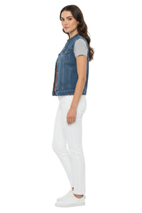 Woman wearing a denim vest, gray shirt, and white pants on a white background