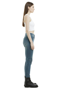 Woman wearing blue jeans and a white top on a white background