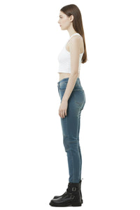 Woman wearing blue jeans and a white top on a white background