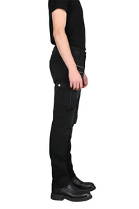 Person wearing black knee-high boots and black pants on a white background
