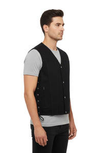 Man wearing a black vest over a gray shirt on a white background