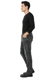 Man wearing black long-sleeve shirt and gray jeans standing against a white background