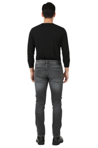 Person wearing a black long-sleeve shirt and gray jeans on a white background