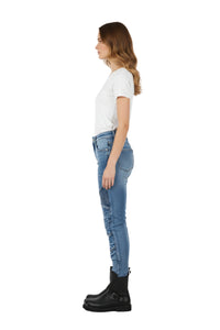 Woman wearing blue jeans and black boots on a white background