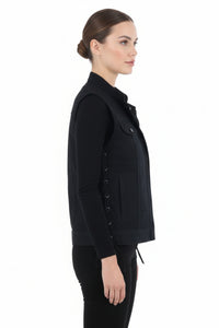 Woman wearing a black vest over a black shirt on a white background