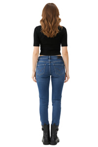 Person wearing blue jeans and a black top on a white background
