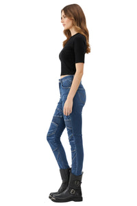 Woman wearing blue jeans and black boots on a white background