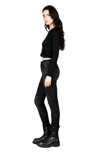 Woman wearing a black outfit with black boots on a white background