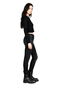 Woman wearing a black outfit with black leather pants on a white background