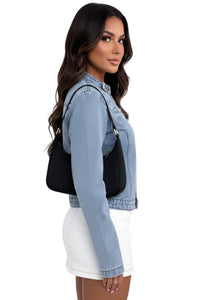 Woman wearing a denim jacket with a black bag on a white background