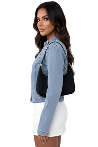 Woman wearing a denim jacket with a black bag on a white background
