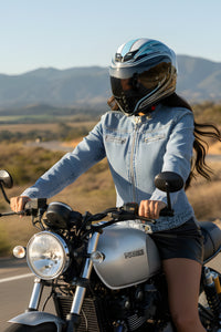 Person riding a motorcycle with mountains in the background